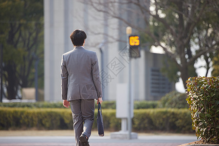 走在人行道上的职场男性背影图片