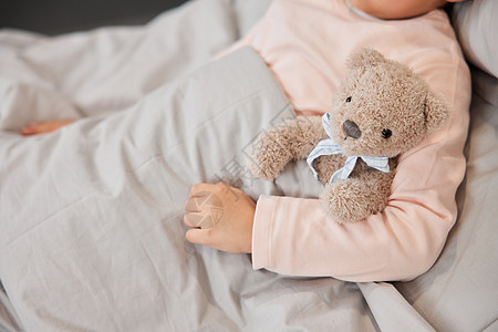 抱着玩偶熊的小女孩生病住院特写高清图片