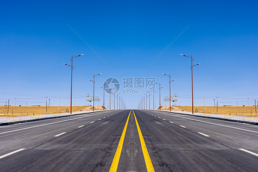 蓝天下的公路和路灯图片