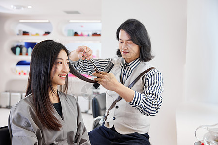 青年理发师给顾客修剪头发图片