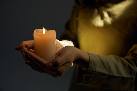 捧着蜡烛的手祈福背景图片