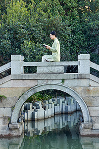坐在桥边看书的素雅美女图片