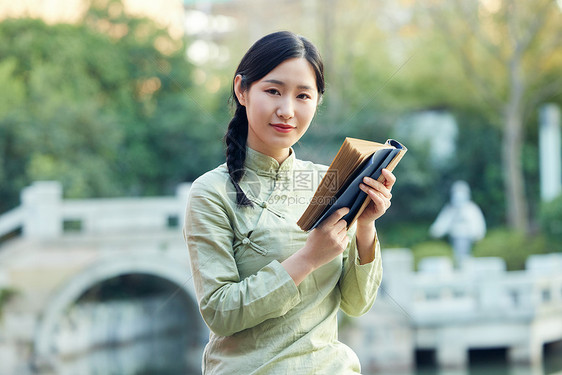 气质女性户外赏植看书图片