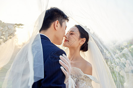 户外举行婚礼的新郎新娘甜蜜接吻背景图片