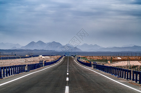 沙漠戈壁通往山峰的公路背景