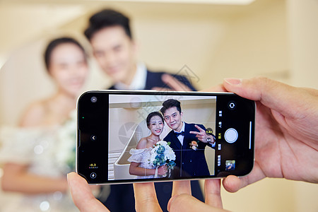 新郎新娘用手机拍照记录新婚图片