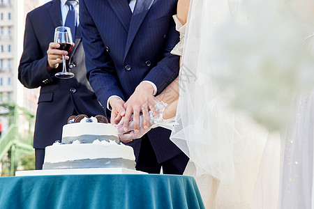 婚礼上的新婚夫妻切蛋糕特写背景图片