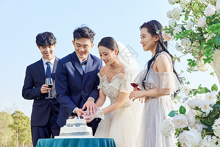 户外婚礼上的新婚夫妻一起切蛋糕背景图片