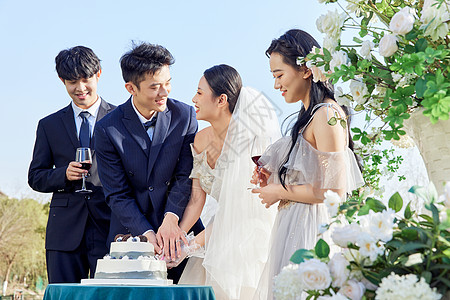 户外婚礼上的新婚夫妻切蛋糕背景图片