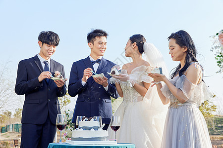 举行户外婚礼的新郎新娘吃蛋糕庆祝图片