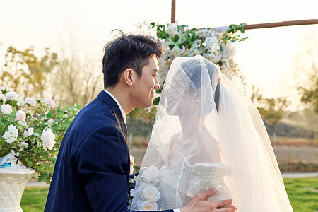 婚礼上的新郎新娘甜蜜接吻背景图片