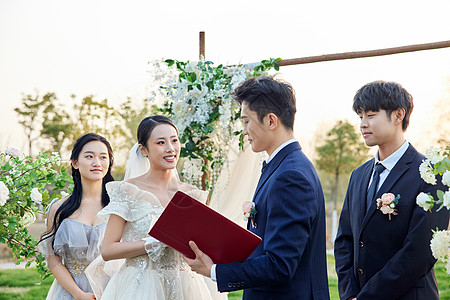 新婚夫妻在户外婚礼上读宣誓词图片