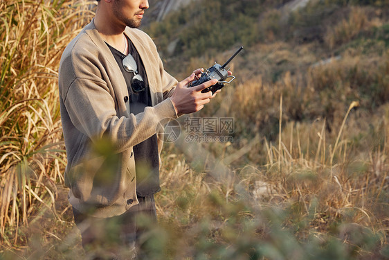 操控无人机遥控器的航拍摄影师特写图片