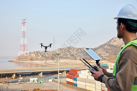 航拍摄影师使用无人机勘探港口图片