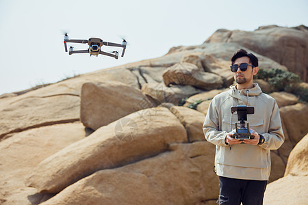 航拍摄影师使用无人机拍摄山景图片