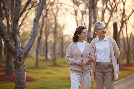 夕阳下老年闺蜜一起在公园散步图片