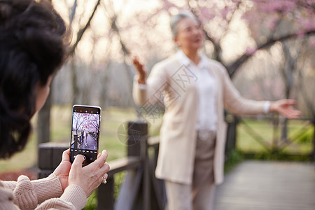 野外聚会用手机给老奶奶拍照片背景
