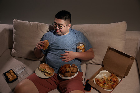肥胖居家男士夜晚吃汉堡图片