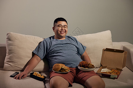 居家肥胖男青年吃夜宵看电视图片
