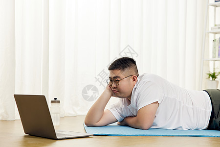 胖子男生瑜伽垫上看视频教程图片