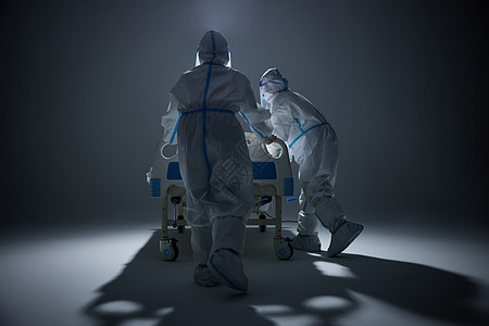 穿防护服推着病床奔跑的医护人员背影图片