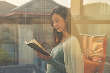 孕妇妈妈在阳台上休息看书图片
