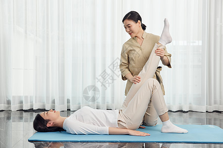 月嫂帮产妇做产后护理瑜伽背景图片