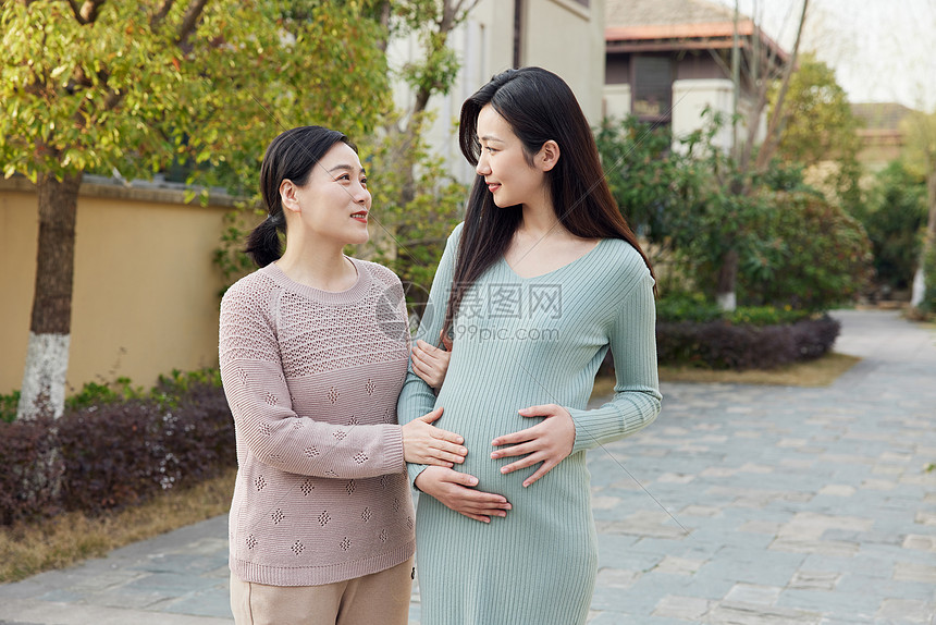 母亲陪怀孕的女儿外出散步图片