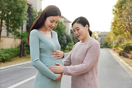 妈妈陪怀孕的女儿外出散步图片