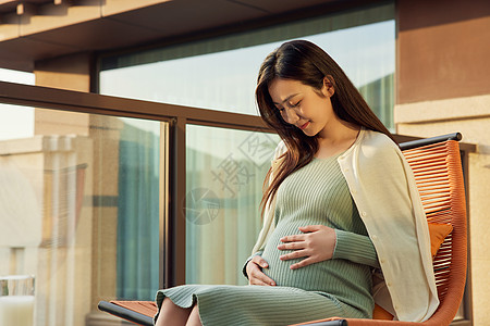 孕妇妈妈在阳台上休息看书图片