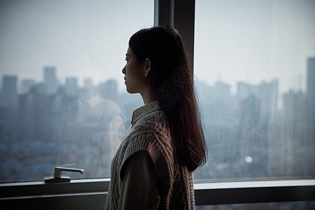青年女性独自在家看向窗外图片素材