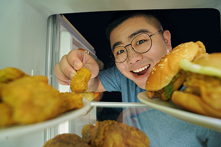 冰箱挑选美食的肥胖男青年图片