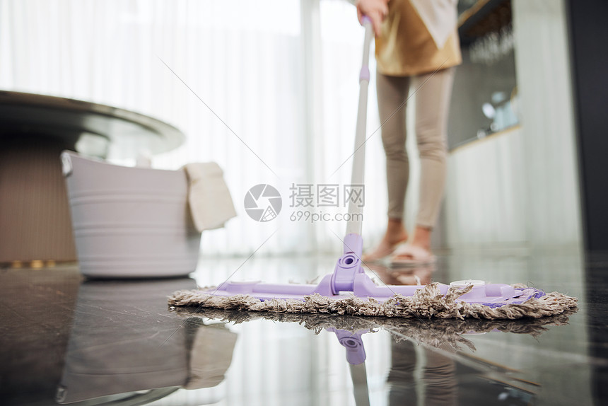 用拖把拖地的女性特写图片