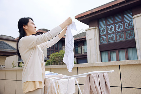 室外晾晒衣服的女性形象图片