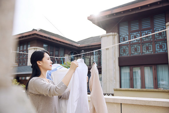 室外阳台晾晒衣服的女性形象图片