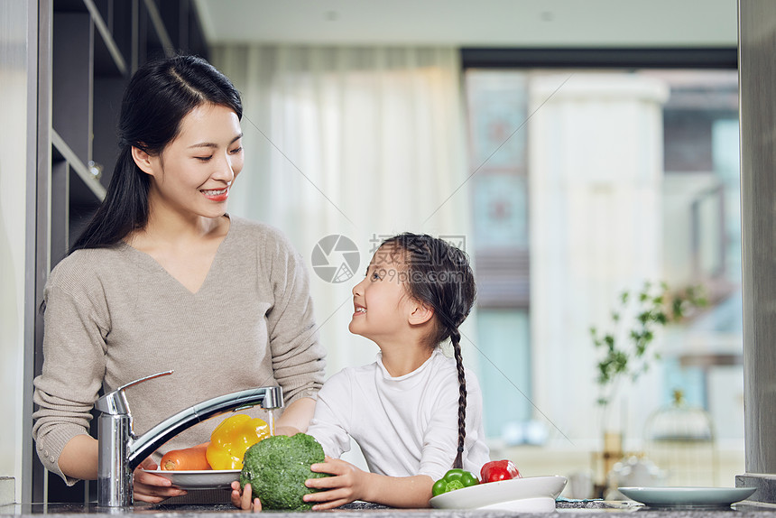 在厨房里一起洗菜的母女图片