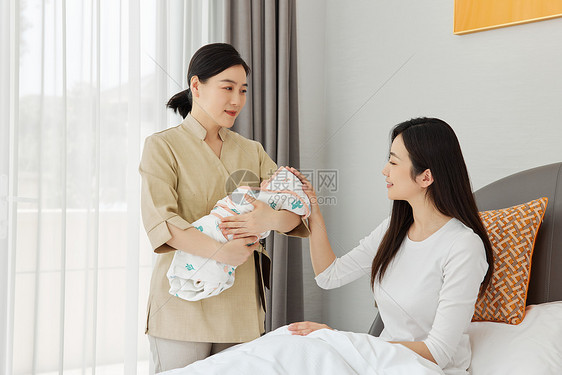 月嫂帮坐月子的母亲照顾新生婴儿图片