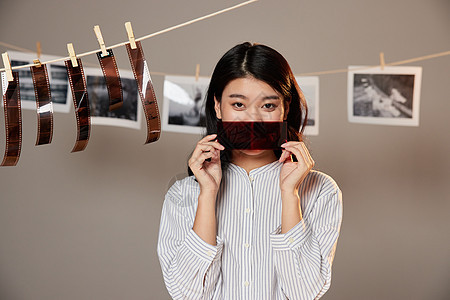 在暗房检查胶片的女摄影师背景图片