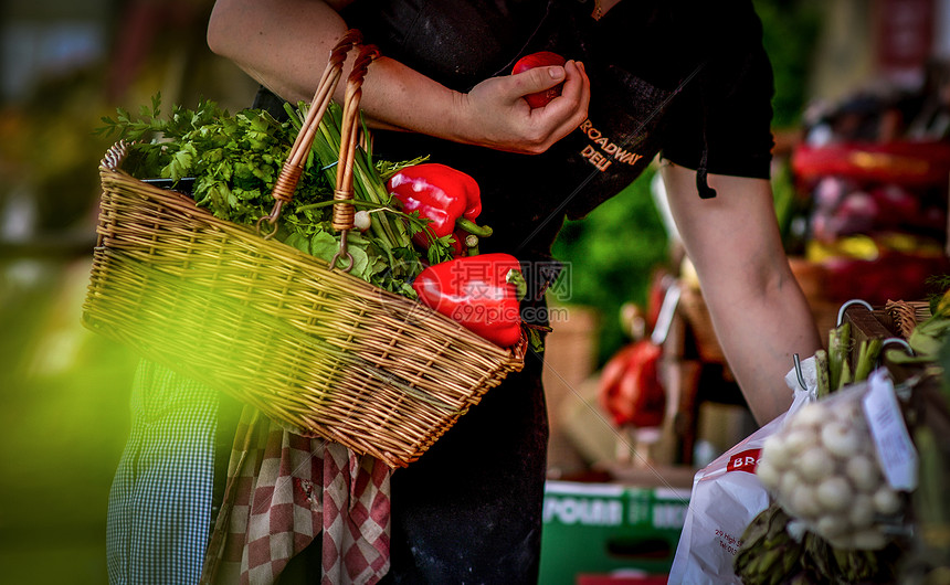 一名妇女提着菜篮在菜市场采购蔬菜xinxian图片