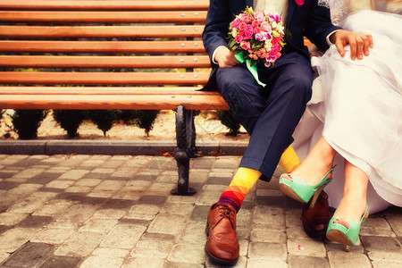 新娘和新郎穿着鲜艳的衣服坐在长椅上图片