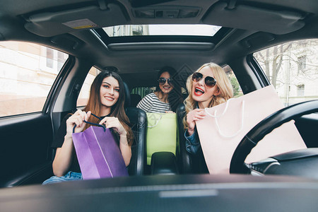 三个女人一起玩乐在车后购物图片