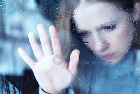 忧郁和悲伤的女孩在雨中的窗口图片
