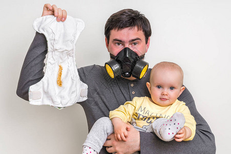 父亲带防毒面具抱着脏尿布和小宝宝图片