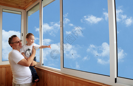 孙子和爷爷站在阳台上看着图片