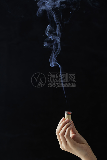 黑色背景手拿艾灸条图片