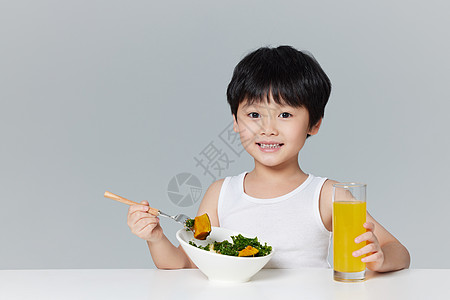 小男孩吃沙拉喝果汁图片