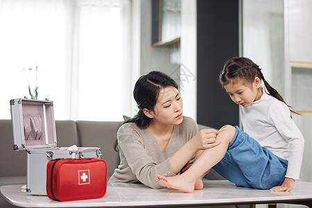 小学生安全母亲给受伤的女儿处理伤口背景