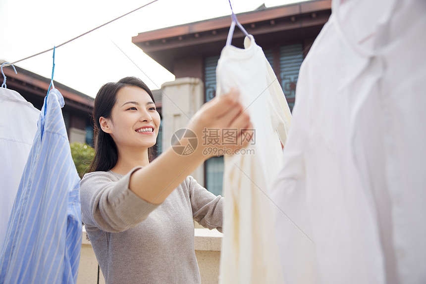 室外晾晒衣服的女性图片