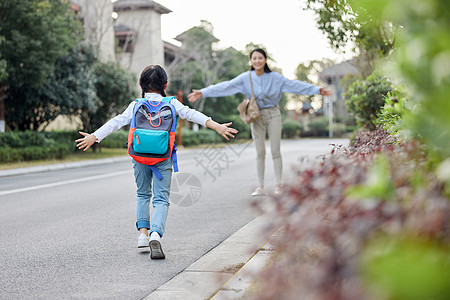 小女孩和花放学回家与母亲拥抱的女儿背景