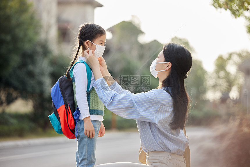 室外妈妈帮女儿戴口罩图片